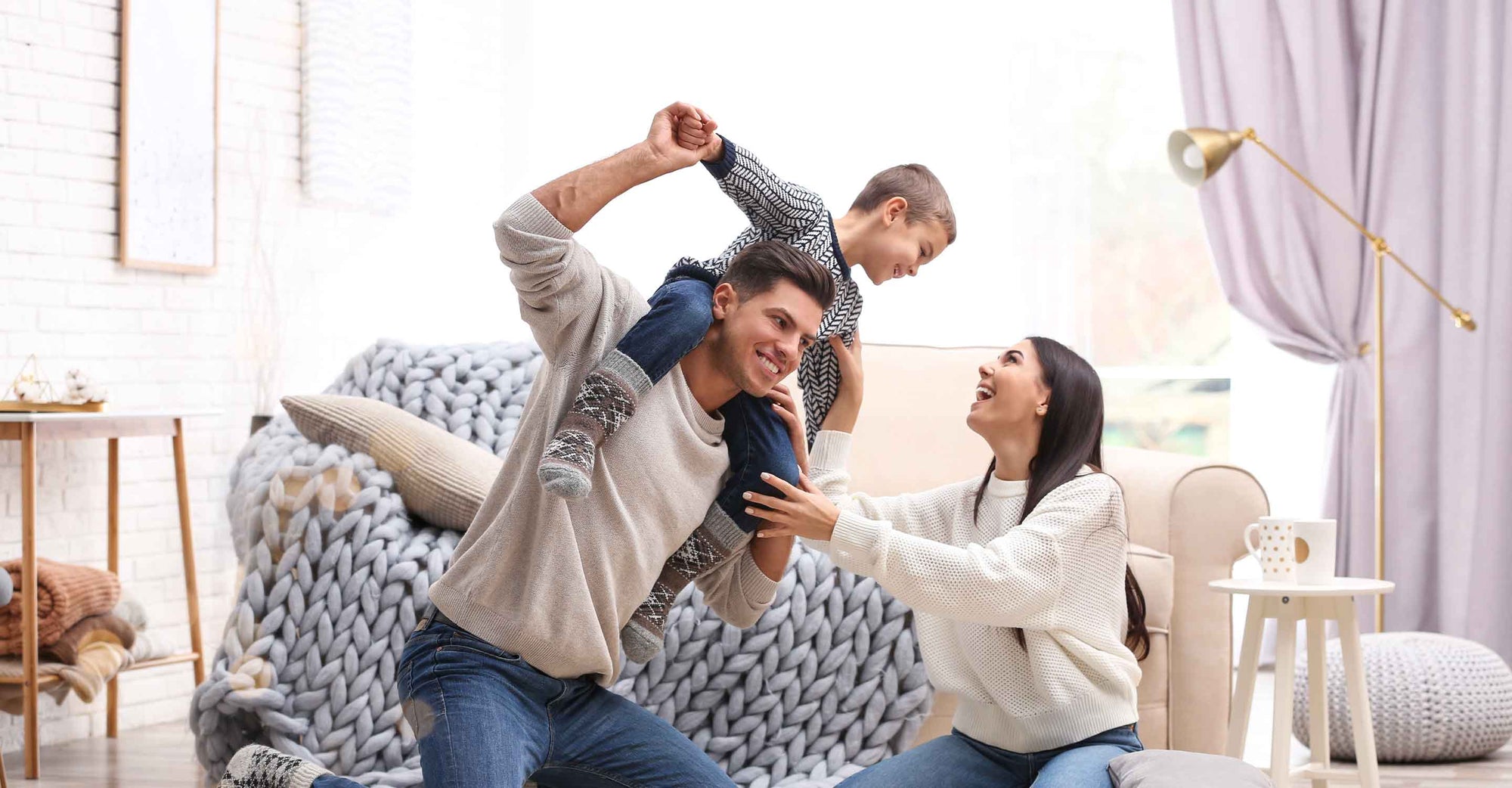 parents with child playing in living room