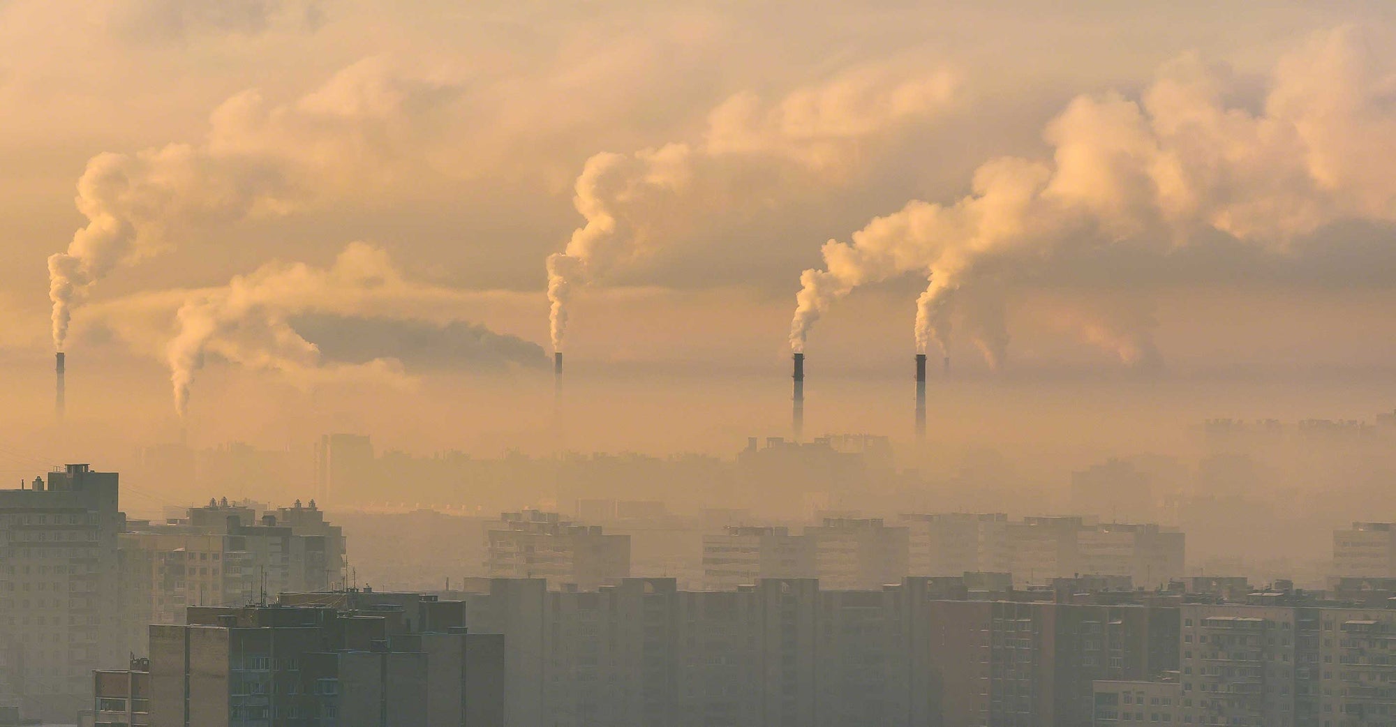 Smokestacks producing yellow air pollution