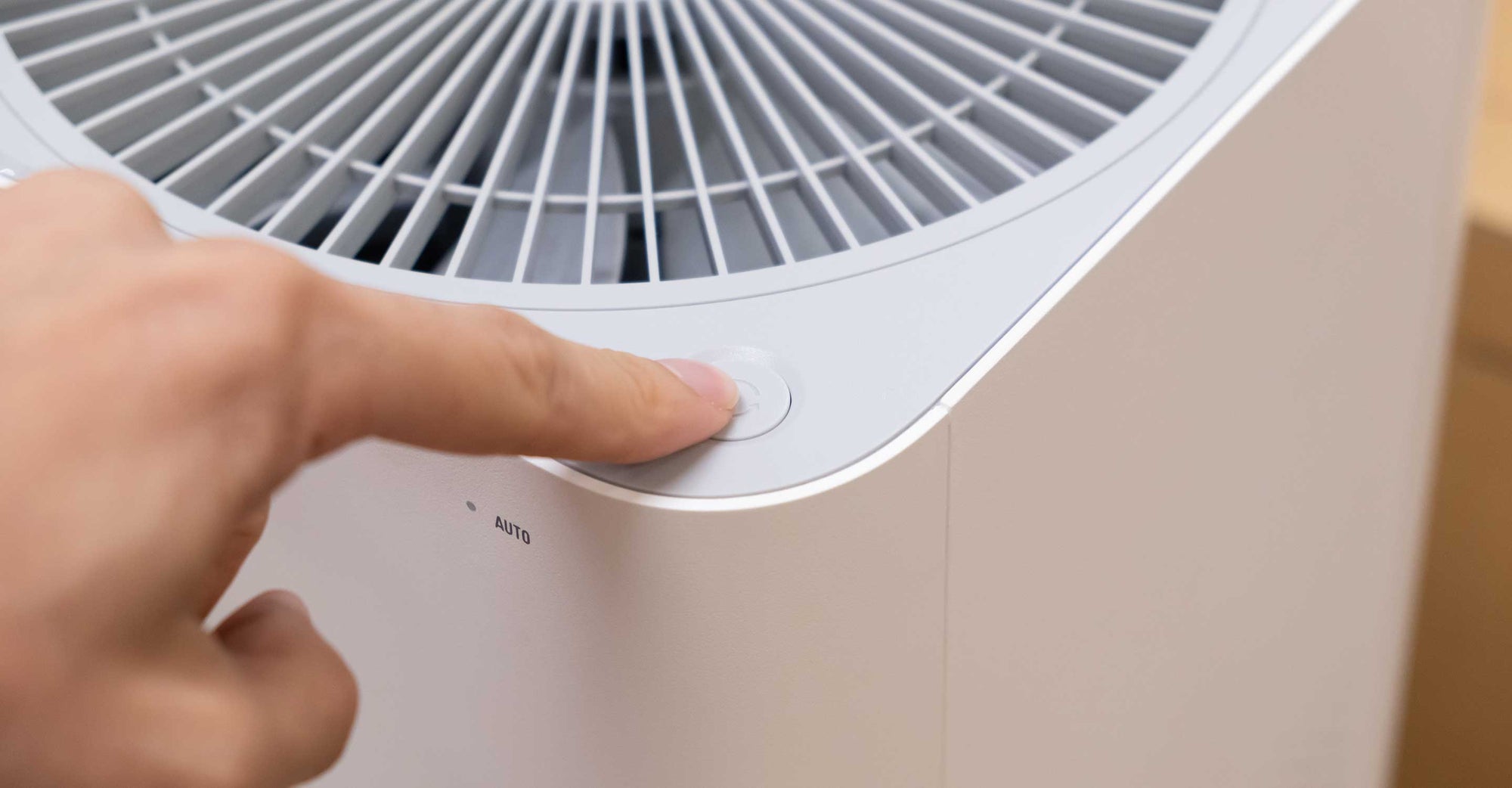 finger pressing power button on ozone air purifier