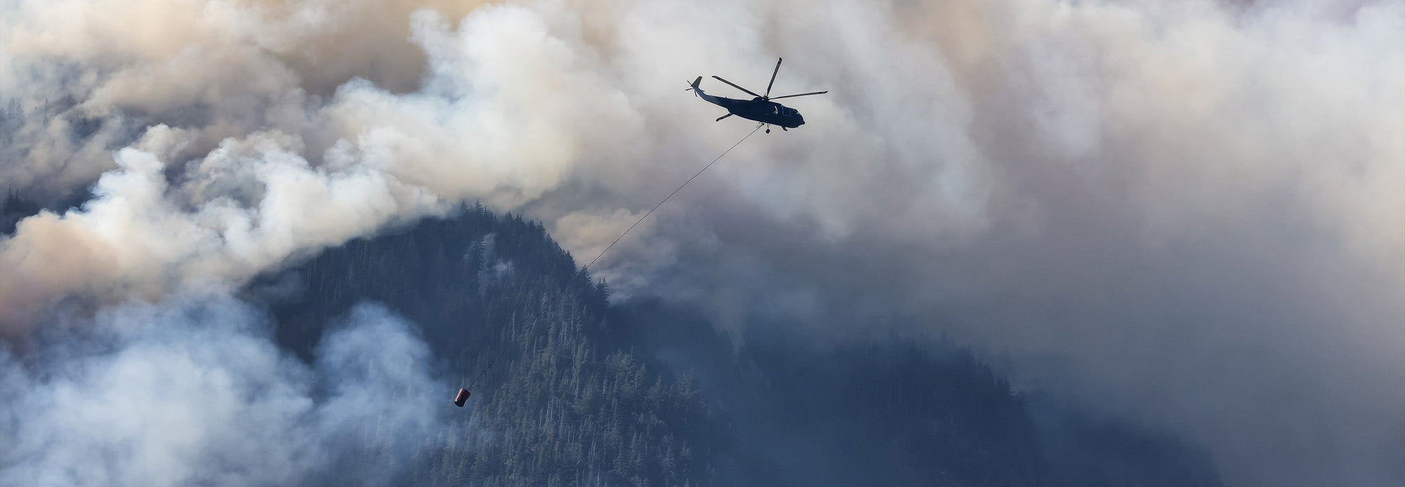 helicopter flying over wildfire